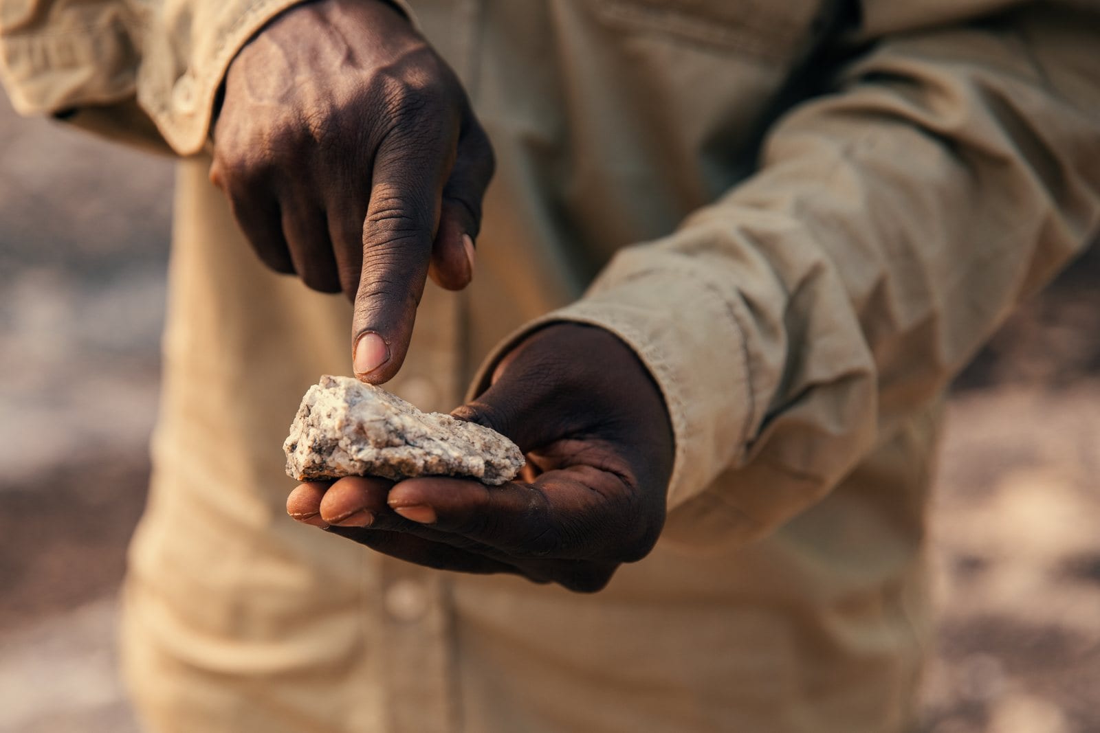 A prospector holding a mineral-bearing rock sample